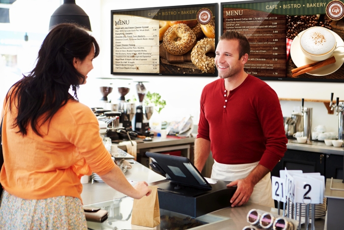 Customer Paying In Coffee Shop Using Touchscreen